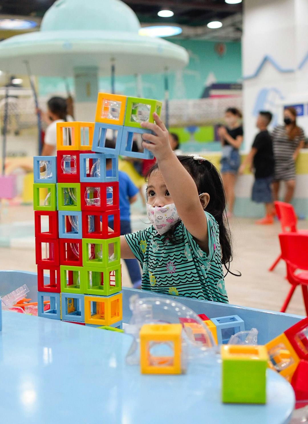 a-little-girl-wearing-a-face-mask-playing-with-blocks-gdxzh3akavg