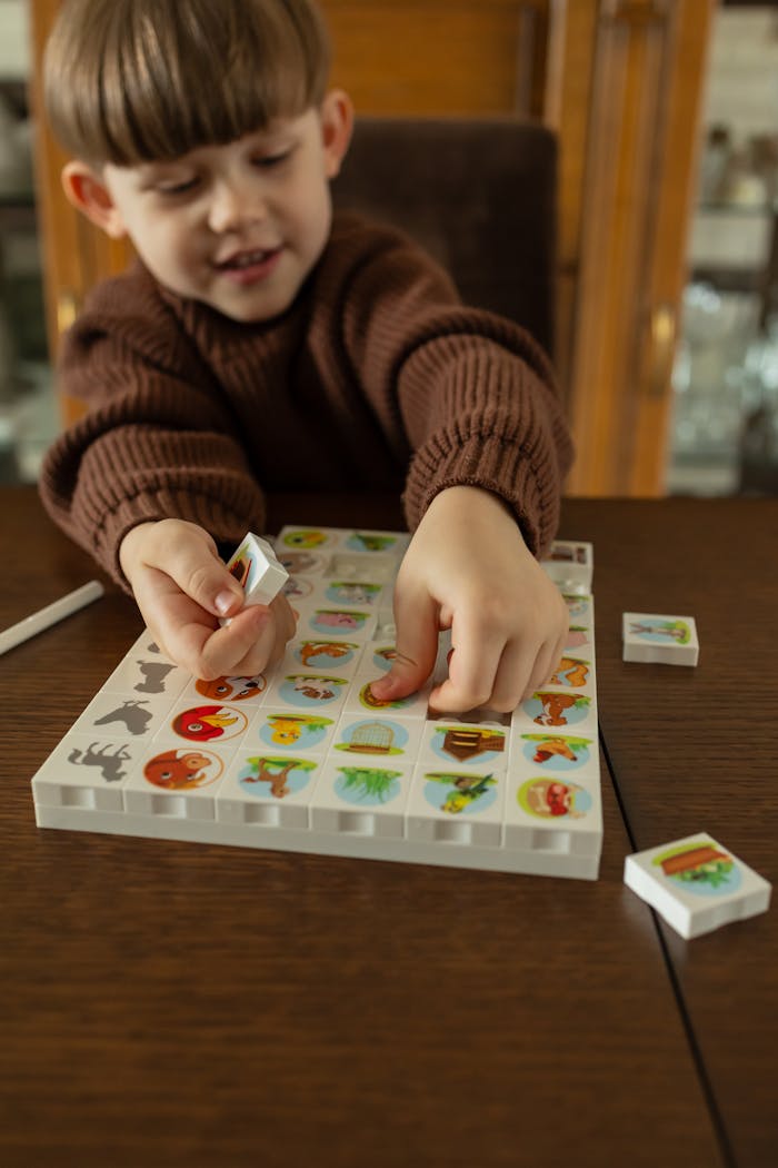 A young boy enjoying a colorful animal picture matching game at home.